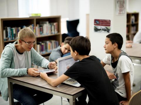 Teens using devices in library