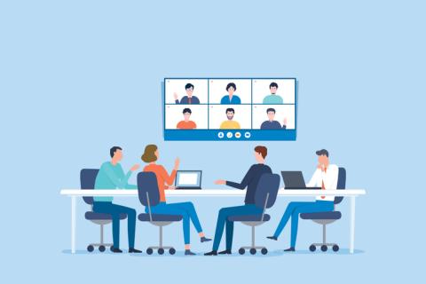 Group of in-person and virtual meeting attendees networking.