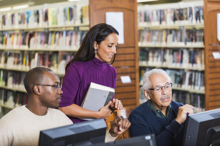 Librarian helping two patrons