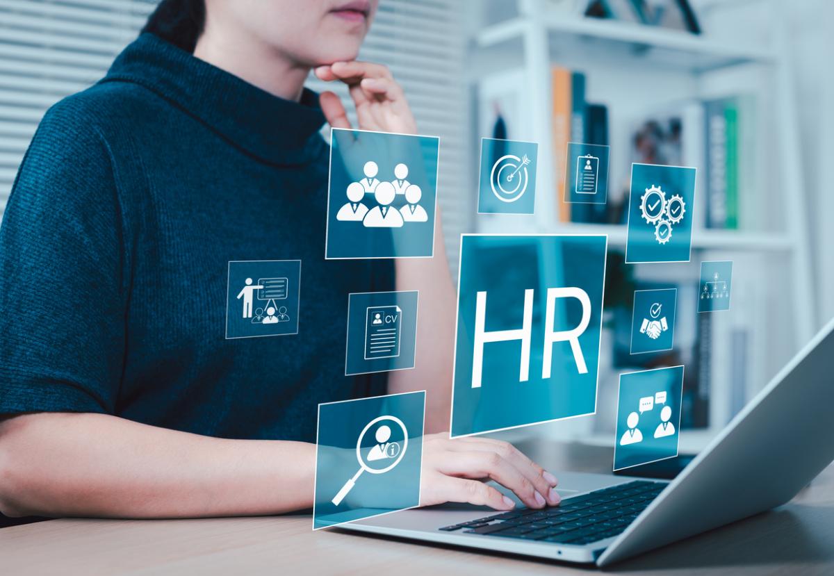 Manager works on laptop with HR icon showing to represent human resources