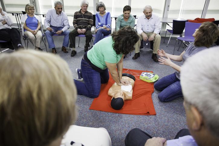 Trainer demonstrating CPR in a library program